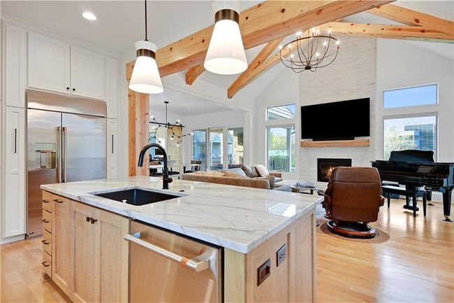 Kitchen with stainless steel appliances, light wood-style flooring, a sink, open floor plan, and high vaulted ceiling | Image 17