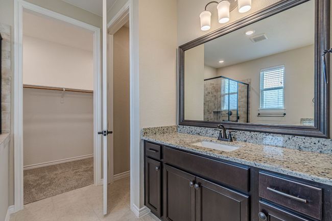 Full bathroom with vanity, a shower stall, a walk in closet, and tile patterned flooring | Image 25