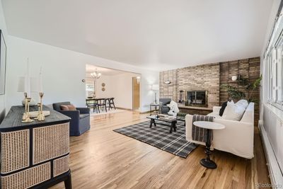 Living room with picture window, hardwood floors and beautiful brick fireplace. | Image 3