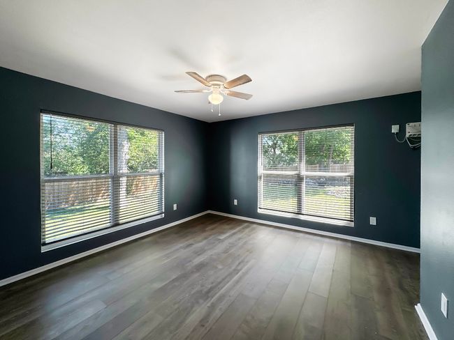 Spare room featuring a ceiling fan, baseboards, and dark wood finished floors | Image 10