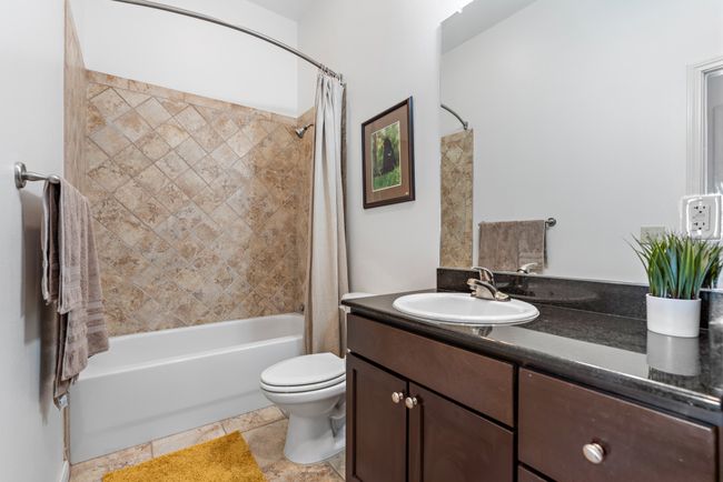 Bathroom with shower / bathtub combination with curtain, vanity, and toilet | Image 14