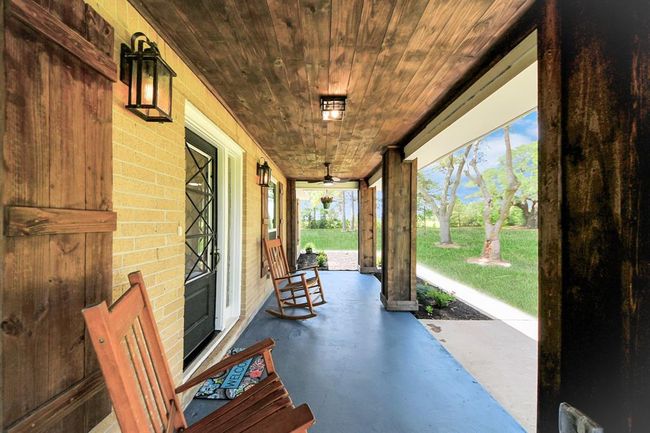 The updated front porch features wide wood posts and a charming ceiling—perfect for morning coffee while watching deer graze under the oaks. | Image 4