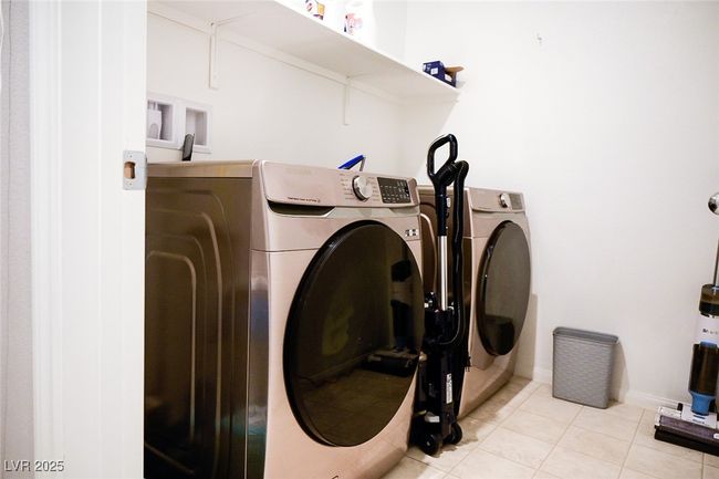 Laundry area featuring independent washer and dryer, baseboards, light tile patterned floors, and laundry area | Image 28