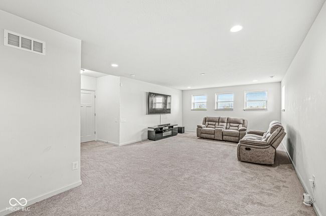 Half a flight of stairs down from the great room is an incredible rec room. Another half flight of stairs down to the unfinished basement with plumbing rough-in for a future bath. | Image 40