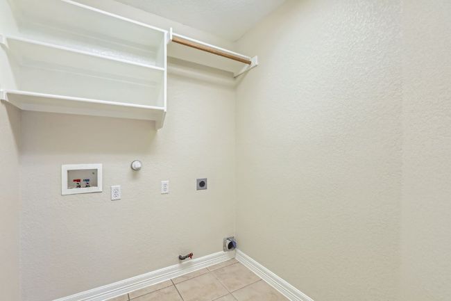Washroom featuring laundry area, light tile patterned floors, washer hookup, gas dryer hookup, and hookup for an electric dryer | Image 35