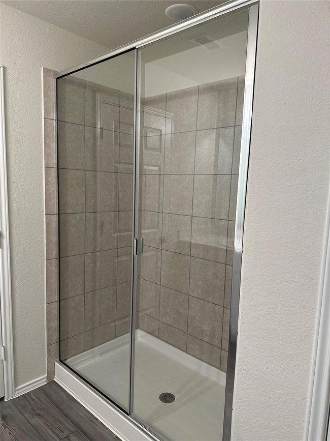 Full bath featuring a stall shower, wood finished floors, and a textured wall | Image 10