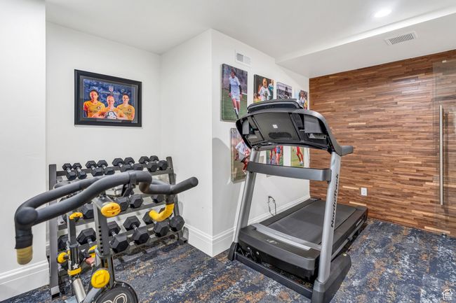 Exercise area with carpet flooring and wooden walls | Image 72