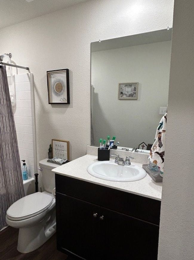 Featuring tub-shower combo, vinyl flooring and stone counter top. | Image 5