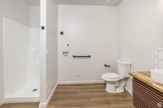 Bathroom featuring a shower, hardwood / wood-style flooring, and toilet | Image 39
