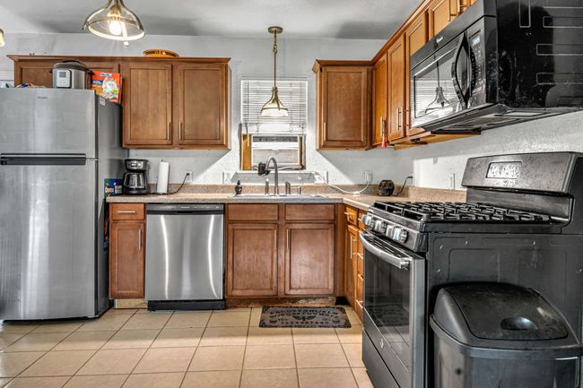 Ceramic-Tiled Kitchen Features Beautiful Modern Cabinetry And Stainless Appliances Plus Pendant And Under-Cabinet Lighting. | Image 5