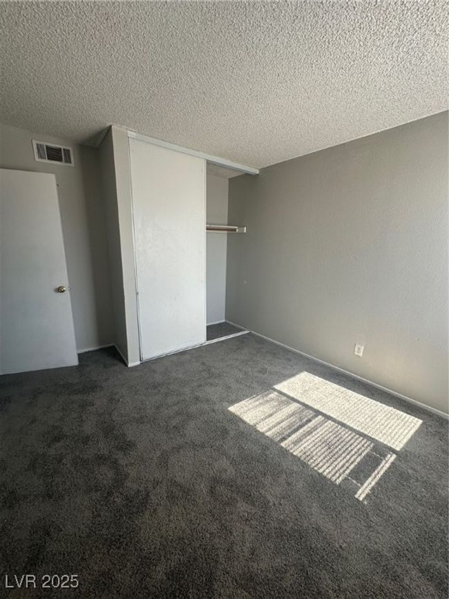 Unfurnished bedroom featuring a textured ceiling, carpet, and a closet | Image 14