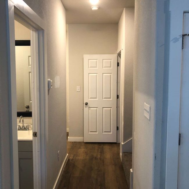 Corridor featuring dark wood-type flooring, a sink, and baseboards | Image 10