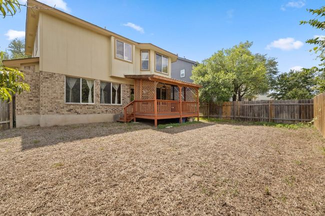 Back of house with brick siding, a wooden deck, and a fenced backyard | Image 32