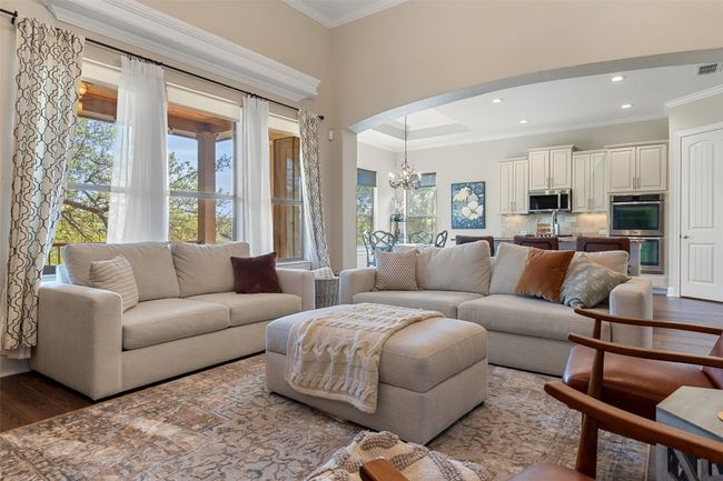 Living room featuring recessed lighting, an inviting chandelier, ornamental molding, and wood finished floors | Image 9