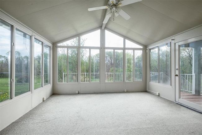 Unfurnished sunroom featuring a ceiling fan, beam ceiling, and a healthy amount of sunlight | Image 19