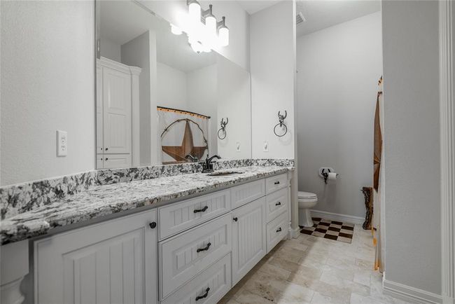 Please notice the long and exotic granite counter tops. The sink is hammered copper and matches the copper in the counter tops perfectly. The floors are natural Travertine tile. | Image 24