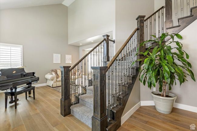 Stairway featuring high vaulted ceiling, baseboards, and wood finished floors | Image 5