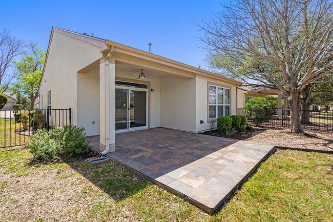 Rear view of house with a ceiling fan, stucco siding, fence, and a patio area | Image 34