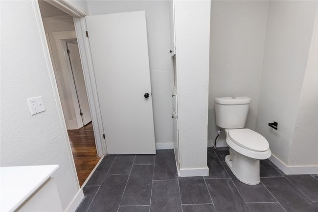 Bathroom featuring toilet, baseboards, and tile patterned flooring | Image 25