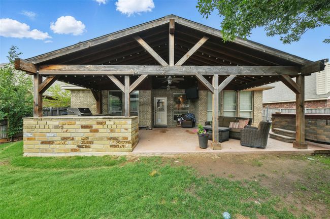 View of patio with exterior kitchen, a gazebo, outdoor lounge area, and a ceiling fan | Image 5