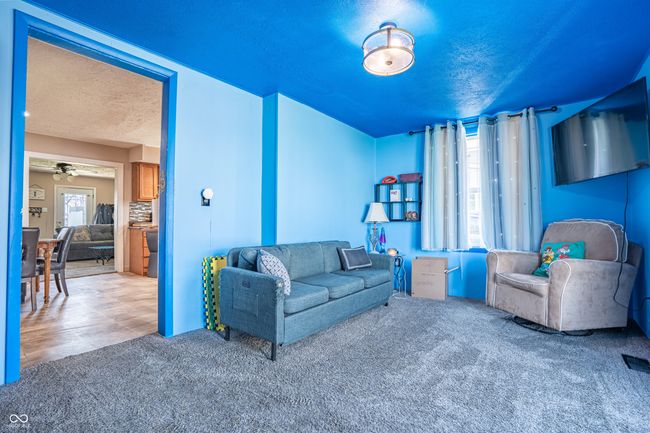 carpeted living room featuring a textured ceiling and a ceiling fan | Image 14