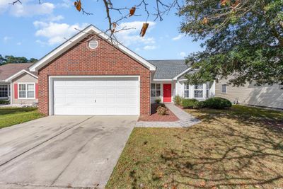 View of front facade with a front yard and a garage | Image 1