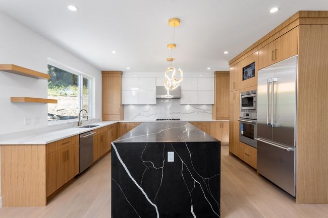 Kitchen with modern cabinets, a sink, backsplash, a kitchen island, and built in appliances | Image 9