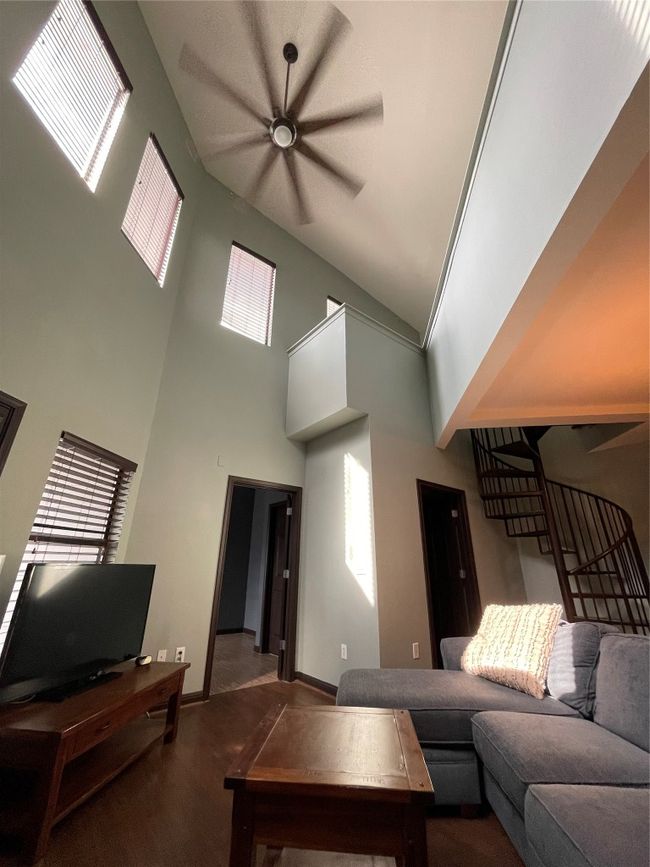 Living area with a towering ceiling, baseboards, and a ceiling fan | Image 19