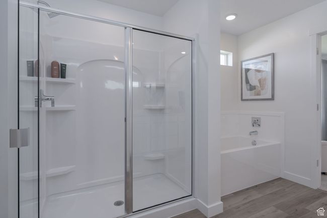 Bathroom featuring a stall shower, wood finished floors, and a bath | Image 8