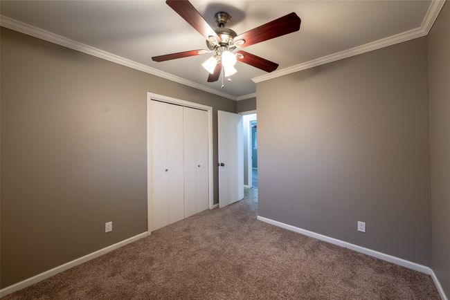 Unfurnished bedroom with carpet floors, ornamental molding, a closet, and ceiling fan | Image 24