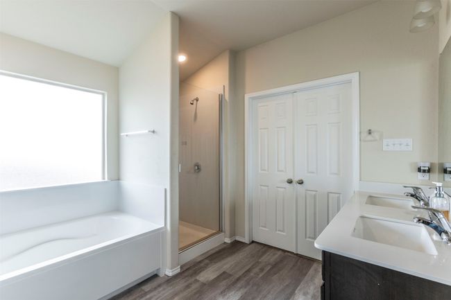 Bathroom featuring a sink, a bath, a shower stall, and wood finished floors | Image 16