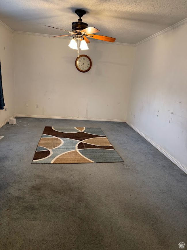Unfurnished room featuring carpet flooring, ceiling fan, a textured ceiling, baseboards, and crown molding | Image 20