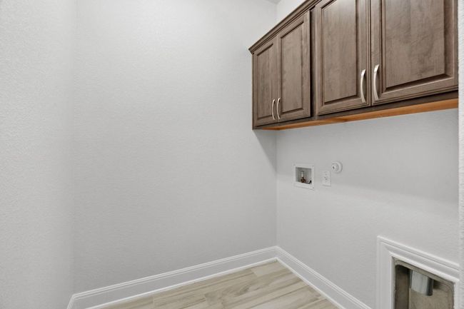 Washroom featuring hookup for a washing machine, baseboards, cabinet space, light wood-style floors, and hookup for a gas dryer | Image 28