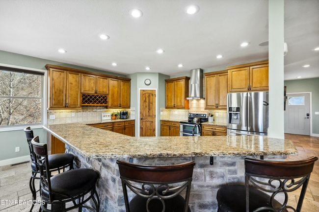Large breakfast bar, casual dining and entertaining space in this open concept kitchen. | Image 13
