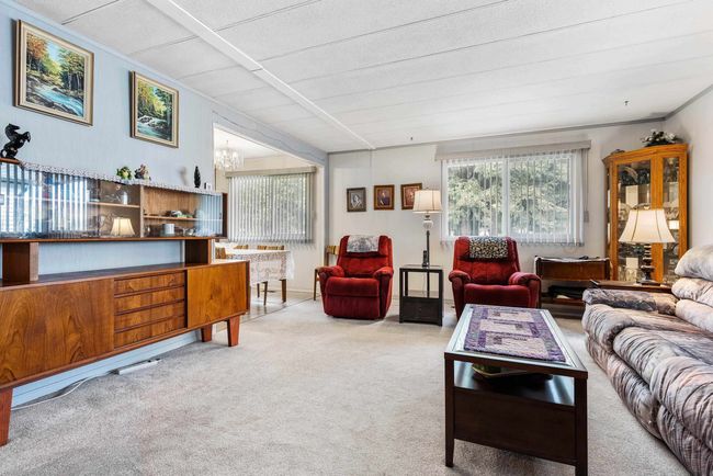 Living room featuring an inviting chandelier and light carpet | Image 6