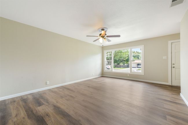 Empty room featuring ceiling fan and wood finished floors | Image 6