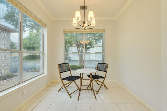 Dining room featuring plenty of natural light, a chandelier, crown molding, and light tile patterned floors | Image 17