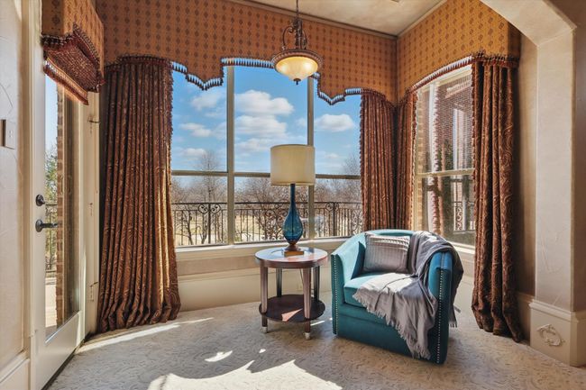 The sitting area in the primary bedroom overloooks the pool and golf course and has a door to the private patio. | Image 20