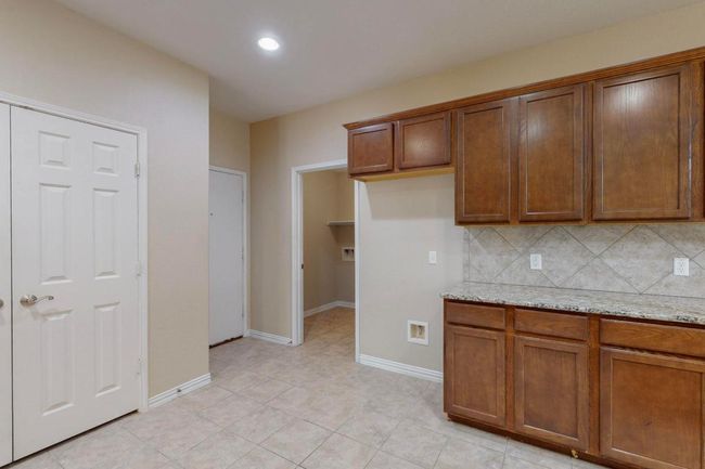 Tons of cabinets and this buffet area too. Bring on the holiday deserts! Door leads to a private utility room. | Image 5