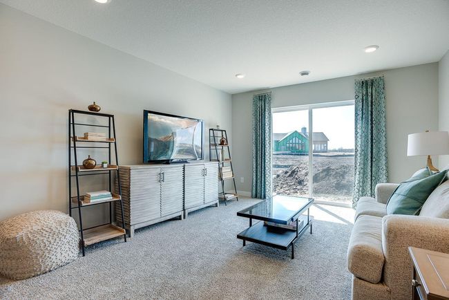 The Finnegan's lower-level rec room. This one shows a walkout sliding glass door, which is also featured in the home for sale. Photo of model home, colors and selections shown may vary | Image 14