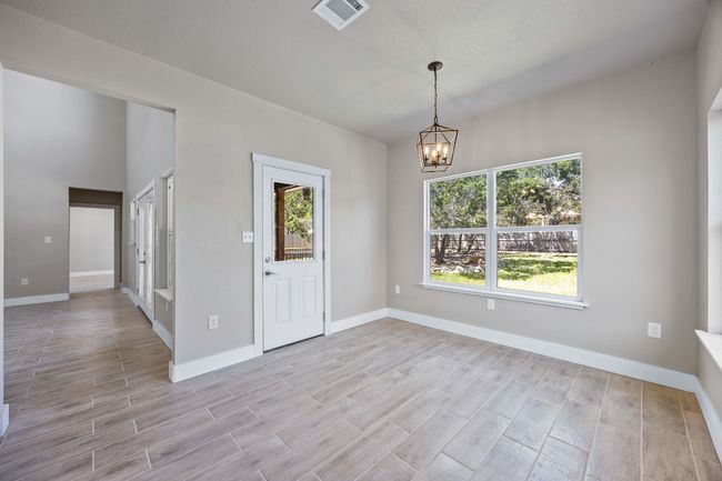 Spare room with baseboards, light wood-style floors, a notable chandelier, and visible vents | Image 8