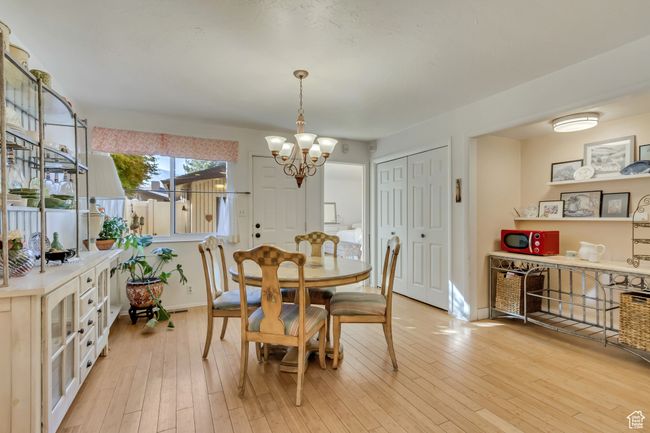Dining area with light wood-type flooring, baseboards, and an inviting chandelier | Image 4