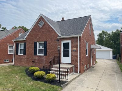 View of front facade with a garage, a front lawn, and an outbuilding | Image 1