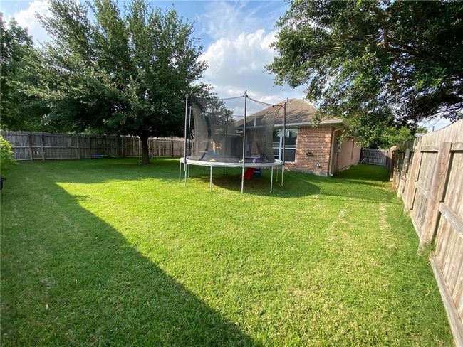 Fenced backyard with a trampoline | Image 12