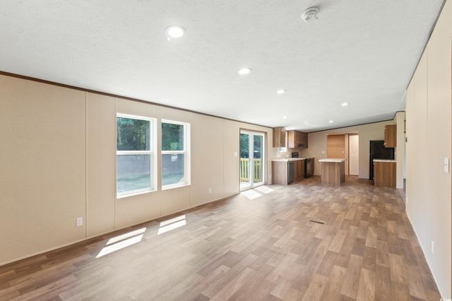 Unfurnished living room featuring light wood finished floors, recessed lighting, a decorative wall, and a textured ceiling | Image 15