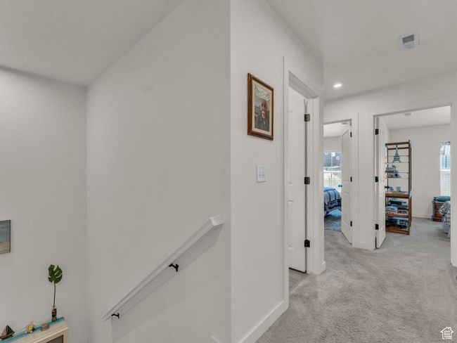 Hall with an upstairs landing, light carpet, healthy amount of natural light, baseboards, and recessed lighting | Image 13