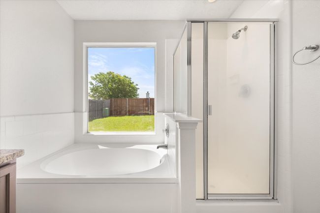 Bathroom featuring a shower stall, a bath, and vanity | Image 15