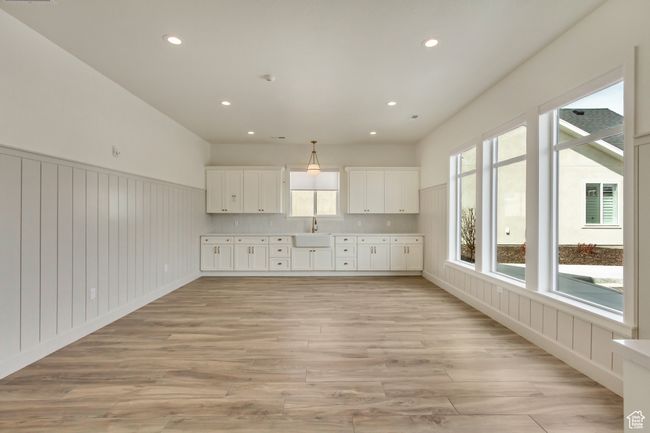 Interior space featuring recessed lighting, light countertops, a sink, light wood-type flooring, and white cabinetry | Image 37