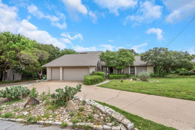 View of front facade featuring brick siding, a garage, driveway, roof with shingles, and a front lawn | Image 6