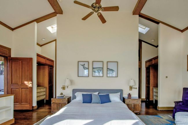Bedroom featuring dark hardwood / wood-style flooring, a skylight, high vaulted ceiling, ceiling fan, and beam ceiling | Image 22